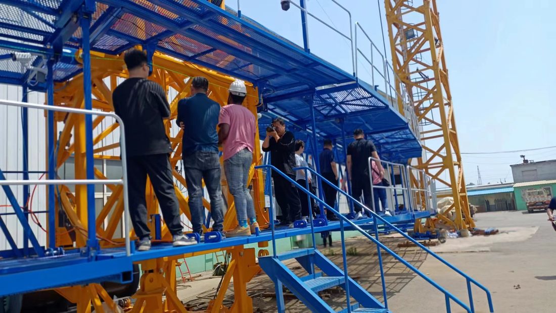 客户与工程师在塔机平台走道上检查设备布局与司机视线